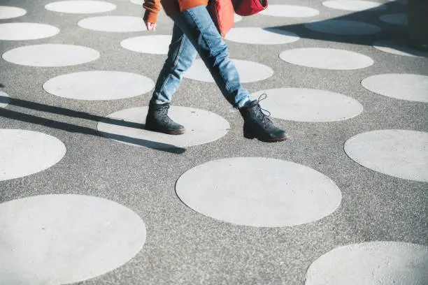 girl going on asphalt town square with white dots in berlin in the afternoon sun