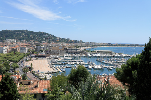 Cannes, France - July 09, 2009: Marina in which many yachts are moored is on Mediterranean. In the background there are hills and city buildings. It is one of the countless wonderful places that is a tourist attraction often visited by many tourists from all over the world.