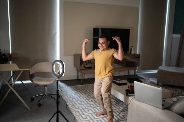 istock Young man with dwarfism recording vlogging at home 1306877090