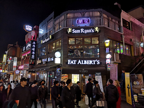 Crowd of people at night in Itaewon, a popular area in Seoul known as \