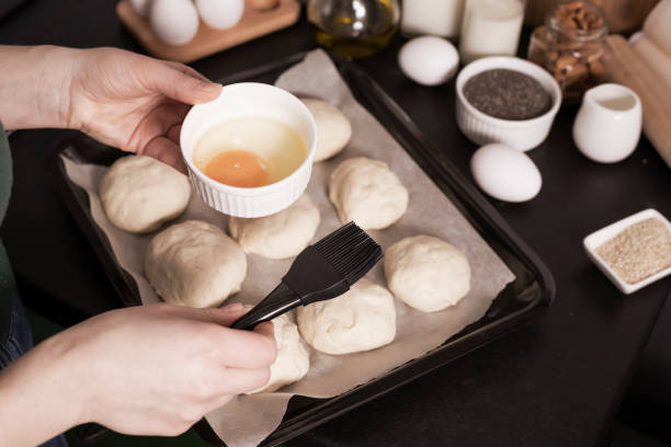 istock yeast dough ready for making homemade buns is on the table among other ingredients for baking bread. a woman prepares pastries, sifts flour. 1306880571
