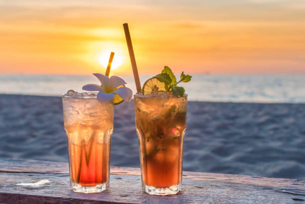 drinks with blur beach and sunset in background - margarita cocktail beach fruit imagens e fotografias de stock