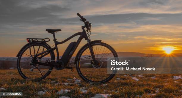 Black And Gray Electric Bicycle In Sunrise Morning Time On Frosty Field Stock Photo - Download Image Now