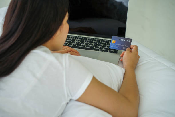 istock Asian young pretty woman work from home with notebook computer on whiter bed 1306887216
