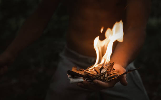 Young man with a burning match in the dark fire