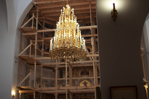 A newly constructed building of the church scaffolding cladding domes chandelier with candles