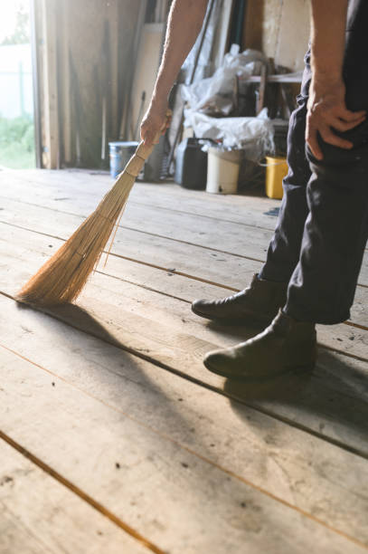istock man sweeps the wood floor. barn cleaning 1306892741