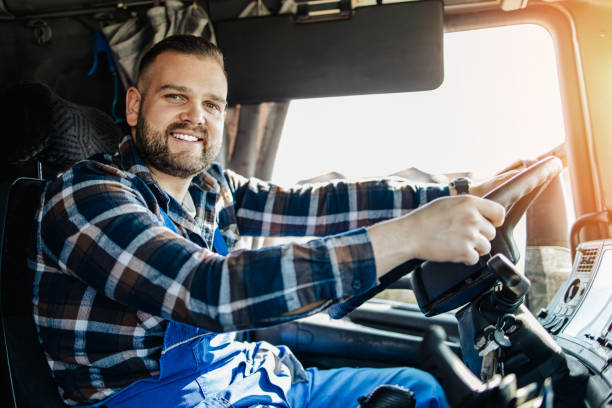Truck driver man Young handsome bearded man driving his truck. View from cabin. truck driver stock pictures, royalty-free photos & images