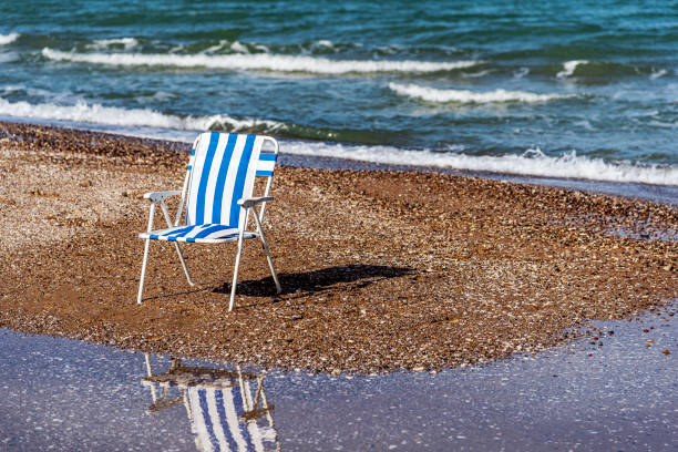 istock Blue striped deck lounge chair on the sand 1306897896