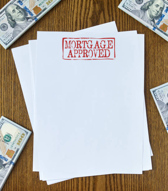 Mortgage approved Looking down on wooden desk with blank paper with “Mortgage approved” stamp 100 dollar bills one hundred dollar stamp stock pictures, royalty-free photos & images