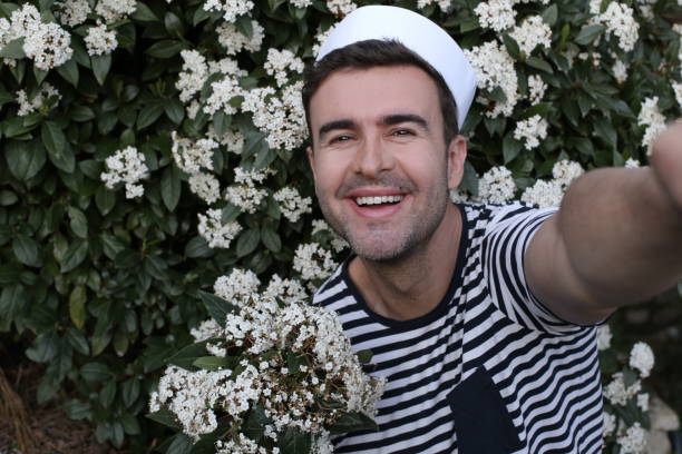 istock Handsome sailor taking a selfie with floral background 1306898267