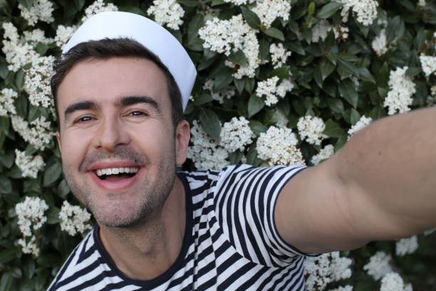 istock Handsome sailor taking a selfie with floral background 1306898270