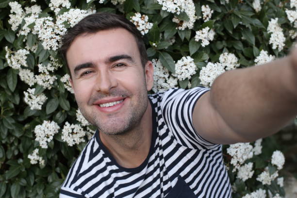 Handsome man taking a selfie with floral background