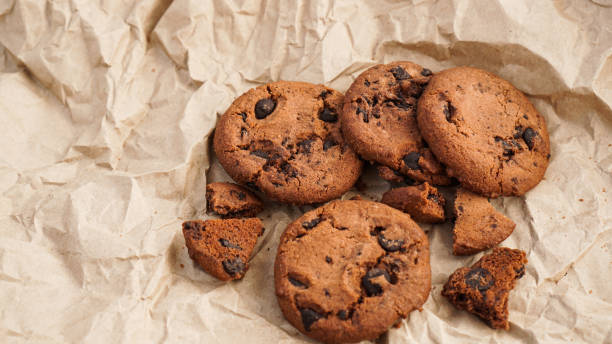 istock Flatview of handcrafted chocolate cookies with chocolate chips on baking paper 1306898323