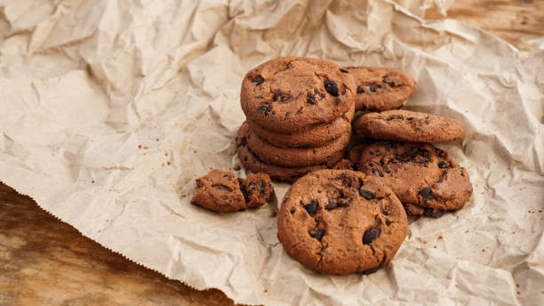 istock Flatview of handcrafted chocolate cookies with chocolate chips on baking paper 1306900371