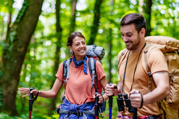 istock Cheerful couple hiking through forest 1306901388