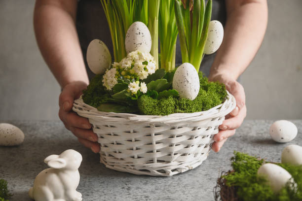 istock Easter table centerpiece with festive eggs, moss and bunny. Spring floral workshop. 1306904767
