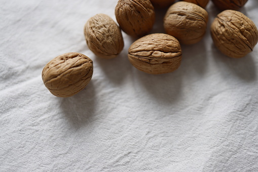 Istanbul, Turkey-March 10, 2021: Walnuts on a white linen cover. The walnuts are shelled. Full Frame, Still life, Studio shot, Flat lay. Shot with Canon EOS R5, Canon RF 35mm Lens.