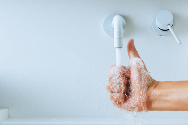 istock thumbs up hand under the mixer spout with flowing water 1306907617