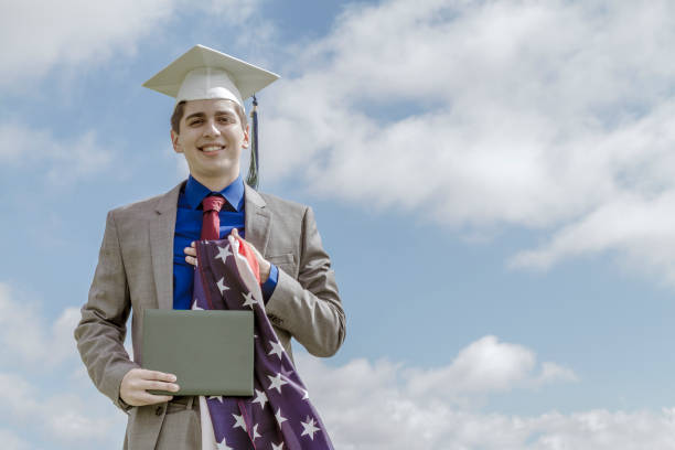 retrato de alegre felicidade belo estudante latino masculino vestindo um vestido e um chapéu, participando de sua cerimônia de formatura nos estados unidos, eua - armed forces latin american and hispanic ethnicity saluting marines - fotografias e filmes do acervo