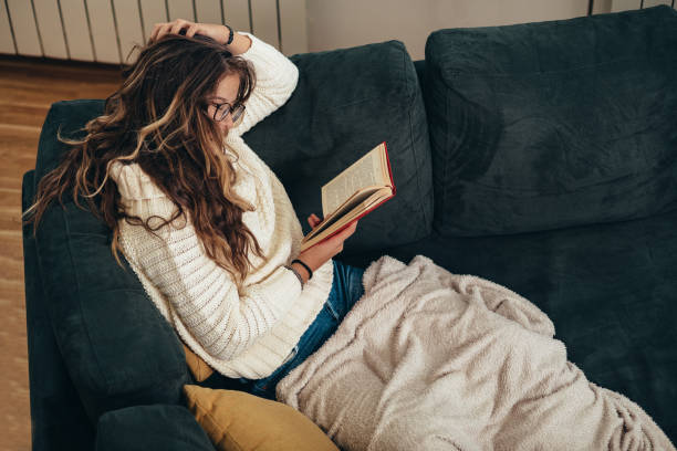istock Woman reading a book at home 1306915259