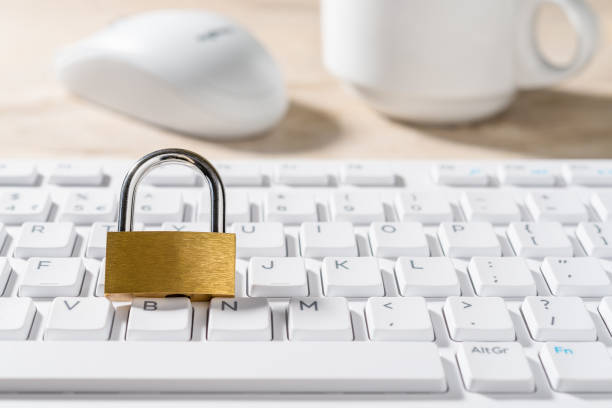 istock Metal padlock on a white computer keyboard. Closed lock on a desktop keypad. Computer and internet security, save confidential data concepts. High key image. Copy space. 1306916161