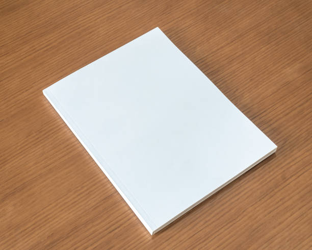 istock Book mockup with blank white front cover page a4 paperback mock up for catalog, magazine, menu, booklet, notebook, portfolio design template on wood table background 1306918492