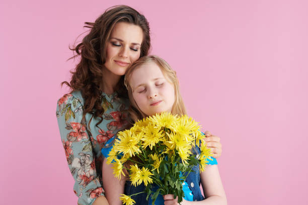 istock relaxed elegant mother and daughter hugging on pink 1306919376