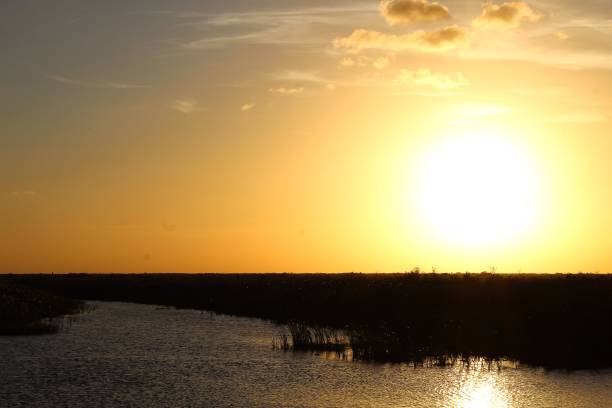 istock large orange sun setting in the water 1306920218