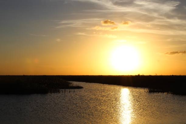 istock large orange sun setting in the water 1306920221