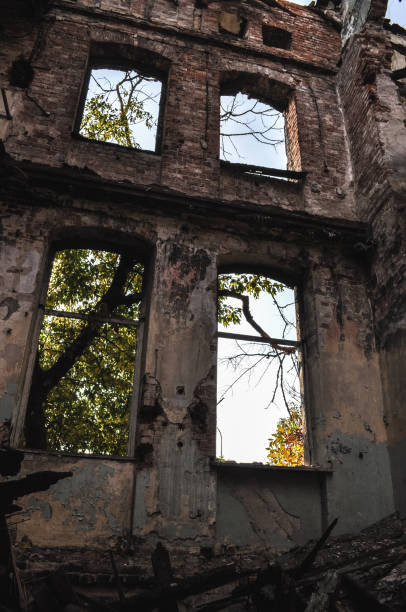 istock damaged windows in old building ruin, damaged brick wall abandoned 1306920933