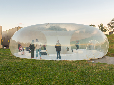 People viewing an innovative architectural meeting space structure made from transparent recyclable and reusable material in Canberra, the Capital of Australia