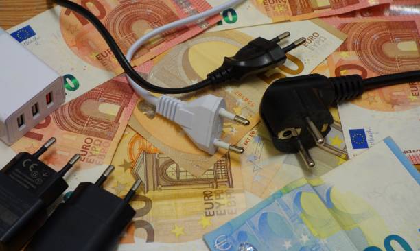 istock power costs - power plug on banknotes 1306922524