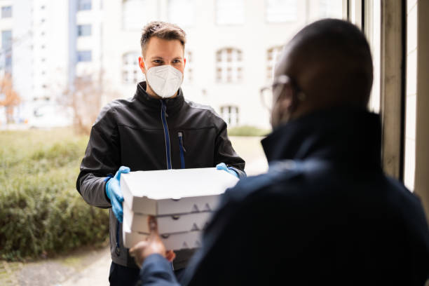istock Receiving Pizza From Delivery Man 1306926303