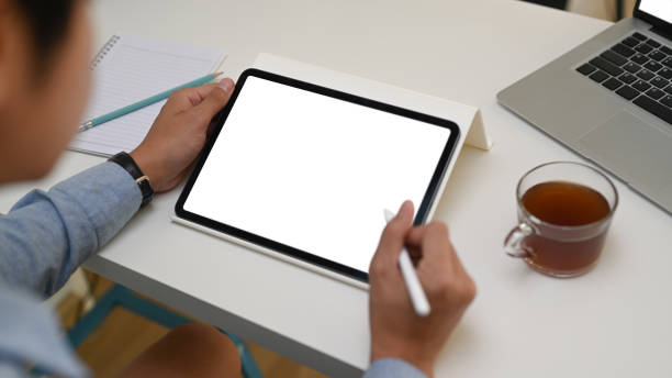 istock Close up view businessman holding mock up digital tablet with empty screen at office desk. 1306932704
