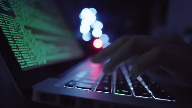 Computer hacker typing on keyboard
