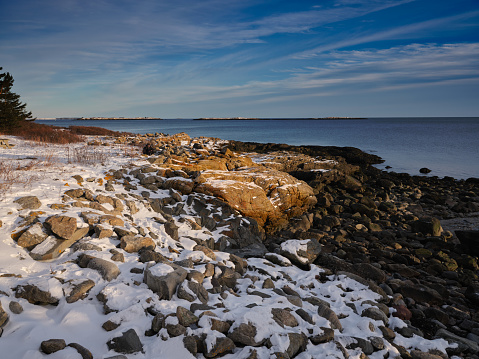 Low-tide on snow covered granite coastal rocks at the entrance to the St. George River in Maine