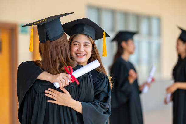 istock Smiling graduates hugging outdoors graduation ceremony at the university 1306947441