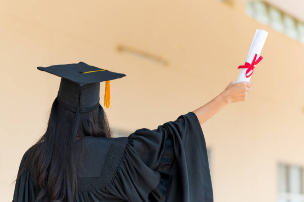 istock Students In Graduation Gowns Showing Diplomas 1306947530