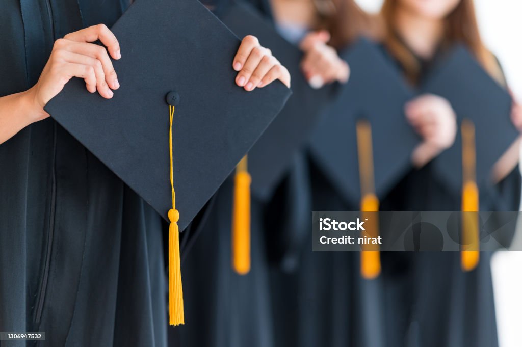Close up group of graduates holding a hat At the graduation ceremony at the university Graduation Stock Photo
