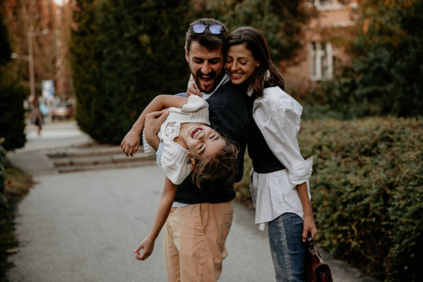 istock Dad and mom spinning and twisting their daughter 1306949551