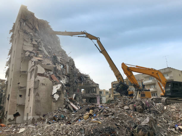 istock Earth digger demolishing a building 1306958892