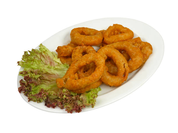 istock Fried squid rings breaded on white oval plate isolated on white 1306960948