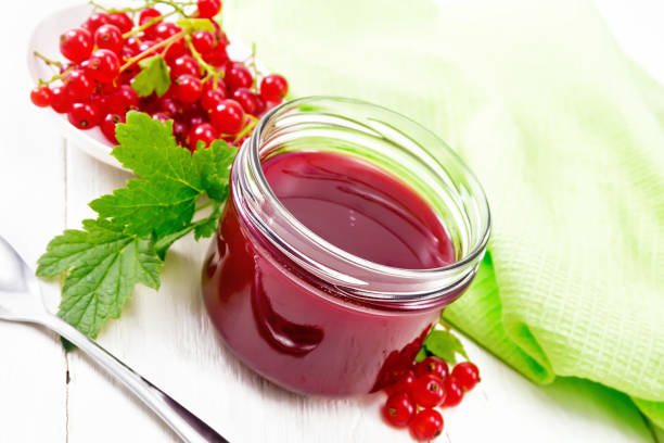 istock Jam of red currant in jar on white wooden board 1306961130