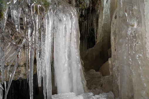 View behind of the frozen Keila waterfall. Icy cave behind a frozen waterfall. Keila-Koa, Estonia. Selective focus.