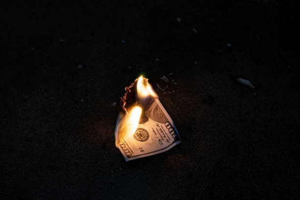 istock Burning dollar bill on concrete floor closeup 1306965154