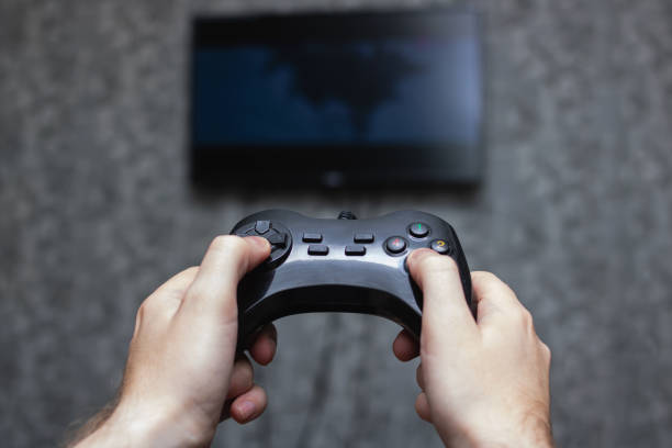 istock Game joystick in hands on background of TV 1306965163