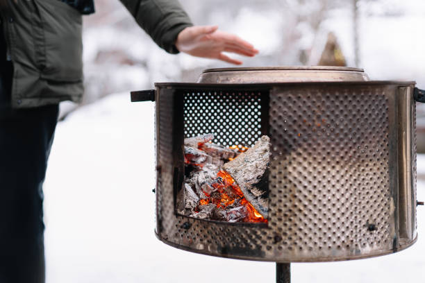 istock Man Warming Hands Over Coal Stove During Winter 1306966300