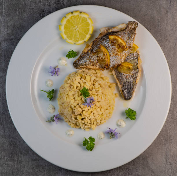 istock Lemon-spiked sea bream fillet, cooked wheat risotto 1306970588