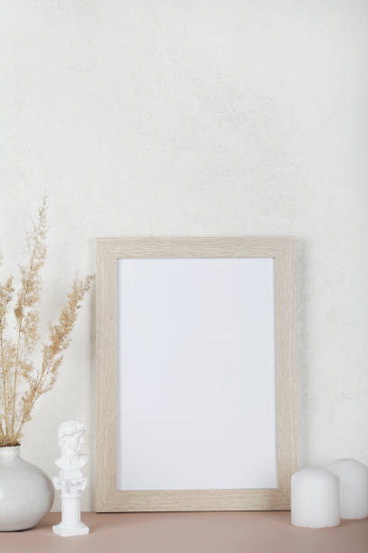 istock Portrait empty wooden frame mockup, dried pampas grass, small statue and candles on white background, interior, home design. Art concept. copy space. 1306973124